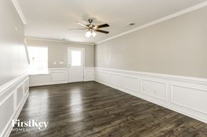 Charlotte house for rent - A spacious room with wood flooring and a ceiling fan.