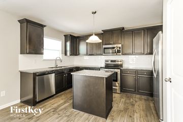 Charlotte house for rent - A kitchen with dark wood cabinets and stainless steel appliances.