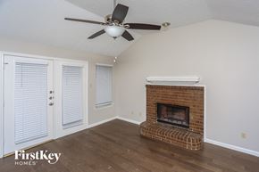 Mesquite house for rent - a living room with a brick fireplace and a ceiling fan