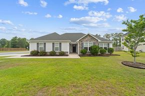 Sneads Ferry house for rent - A house with a grey roof and white walls is surrounded by a green lawn.