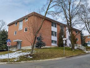 Guelph apartment for rent - A red brick building with a no parking sign in front.