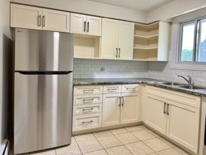 Guelph apartment for rent - A kitchen with a stainless steel refrigerator and white cabinets.