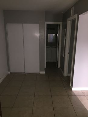 Phoenix apartment for rent - a hallway with white walls and a tiled floor and a door to a bathroom