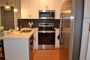 Bay City apartment for rent - a kitchen with stainless steel appliances and white cabinets
