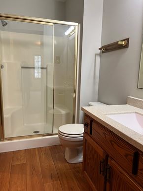 Hartville apartment for rent - A white toilet sits in a bathroom with a glass shower door.