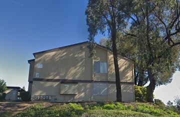 Vallejo apartment for rent - A building with a brown facade is surrounded by greenery.