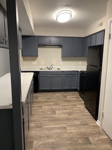 Charlotte apartment for rent - a kitchen with dark blue cabinets and a wood floor