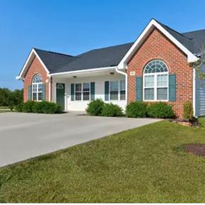 Youngsville apartment for rent - A red brick house with green shutters and a white garage door.