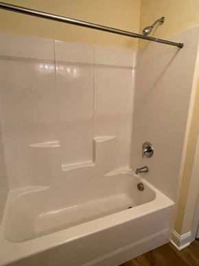 Youngsville apartment for rent - A white bathtub with a silver faucet and a silver shower rod.