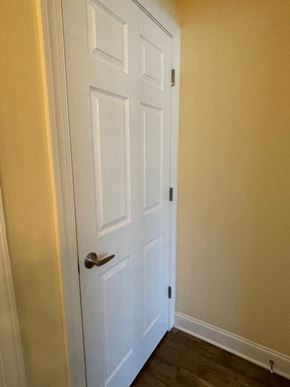 Youngsville apartment for rent - A white door with a silver handle is closed.