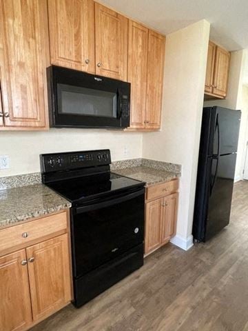 Youngsville apartment for rent - A kitchen with wooden cabinets and black appliances.