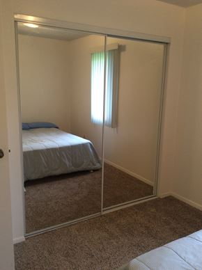 Kenai house for rent - A bedroom with a bed and a mirror.