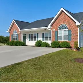 Youngsville apartment for rent - A red brick house with green shutters and a white garage door.