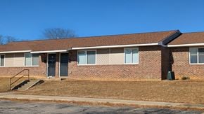 Roxboro apartment for rent - A brick building with a black door and windows.