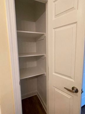 Youngsville apartment for rent - A white door with a handle is open to a pantry with empty shelves.