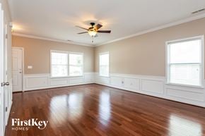 Mooresville house for rent - A spacious room with wooden floors and a ceiling fan.