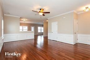 Mooresville house for rent - A spacious room with wooden floors and a ceiling fan.