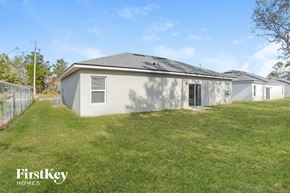 Poinciana house for rent - A house with a fence and grass in front.