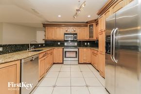 Casselberry house for rent - A kitchen with wooden cabinets and a stainless steel refrigerator.