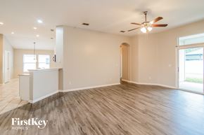 Orange Park house for rent - A spacious room with wooden flooring and a ceiling fan.