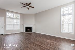 Concord house for rent - A spacious room with a fireplace and a ceiling fan.