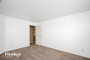 Indianapolis house for rent - a bedroom with white walls and carpet and a door to a closet