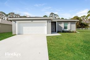 Palm Bay house for rent - a white house with a white garage door and a lawn