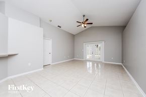 Orlando house for rent - A spacious room with a ceiling fan and tiled flooring.