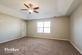 Charlotte house for rent - A spacious room with a ceiling fan and carpeted floor.
