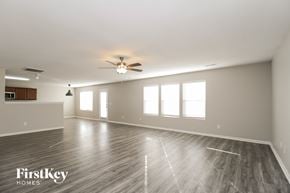 Greensboro house for rent - A spacious room with wooden flooring and a ceiling fan.