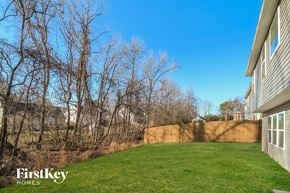 Greensboro house for rent - A backyard with a fence and trees.