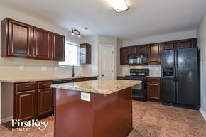 Mcleansville house for rent - a kitchen with black appliances and a granite counter top