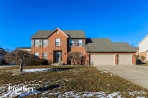 Hamilton house for rent - A large brick house with a garage and a tree in front.