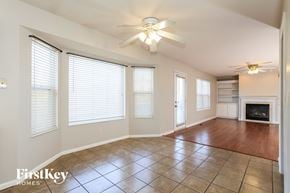 Hamilton house for rent - A spacious room with a fireplace and a ceiling fan.