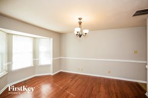 Carmel house for rent - a empty dining room with wood floors and a chandelier