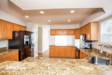 Carmel house for rent - a kitchen with granite counter tops and wooden cabinets