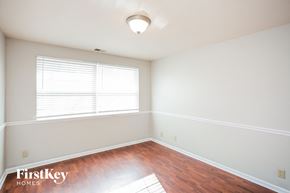 Carmel house for rent - a bedroom with white walls and wood floors and a window