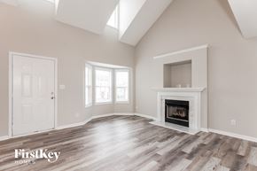 Charlotte house for rent - A spacious room with a fireplace and a door on the left side.
