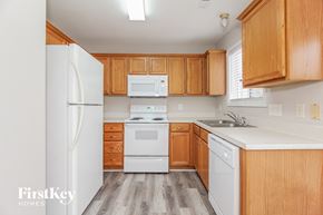 Charlotte house for rent - A kitchen with wooden cabinets and white appliances.