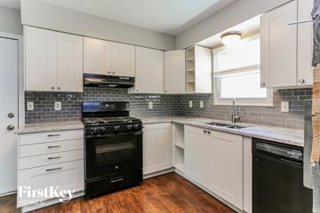 Hilliard house for rent - a white kitchen with black appliances and white cabinets