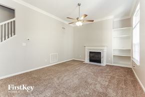 Charlotte house for rent - a living room with a fireplace and a ceiling fan