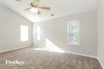 Charlotte house for rent - a living room with carpet and a ceiling fan