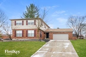 West Chester house for rent - a large brick house with a garage and a lawn