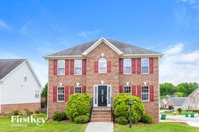 Clemmons house for rent - a brick house with red shutters and a black front door
