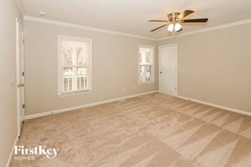 Charlotte house for rent - a living room with carpet and a ceiling fan