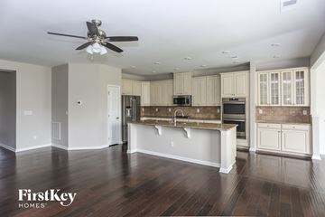 Concord house for rent - a kitchen with white cabinets and a large island and a ceiling fan