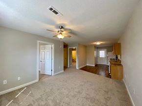 Youngsville apartment for rent - A spacious room with a ceiling fan and carpeted floor.