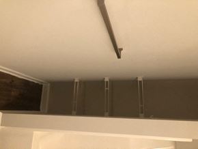 Youngsville apartment for rent - A white shelf with a black pipe running along the ceiling.