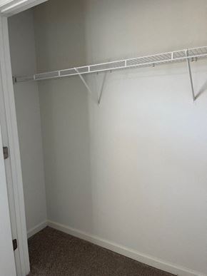 Youngsville apartment for rent - A white closet with a metal rail and carpeted floor.