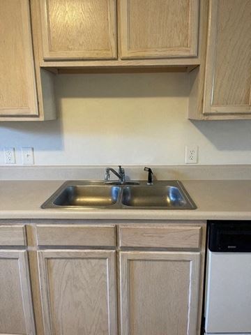 Youngsville apartment for rent - A kitchen with a sink and wooden cabinets.